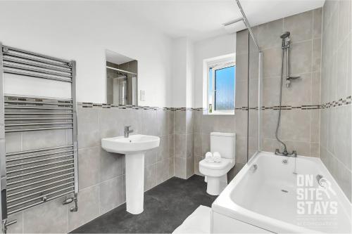 a bathroom with a sink and a tub and a toilet at OnSiteStays - 4 Large Bedrooms 3 Bathrooms 1 WC Parking Garden & Wifi in Basildon