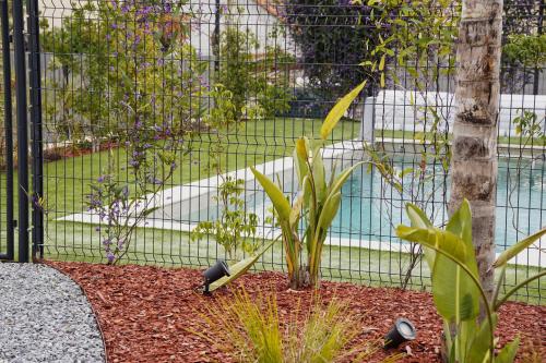 un jardin avec une clôture et quelques plantes dans l'établissement Bas de Villa Vallon des Signes, à La Seyne-sur-Mer