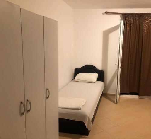 a small bedroom with a bed and a cabinet at Apartmani Čanj in Čanj