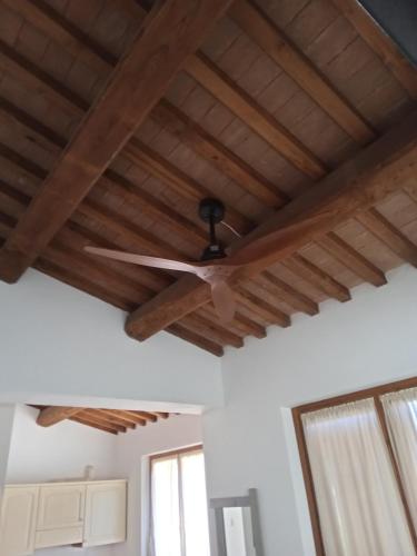 a ceiling fan in a room with wooden ceilings at I TRE POETI in Saturnia