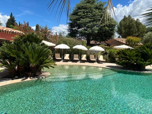 a swimming pool with chairs and umbrellas at Domaine De Respelido in Carros