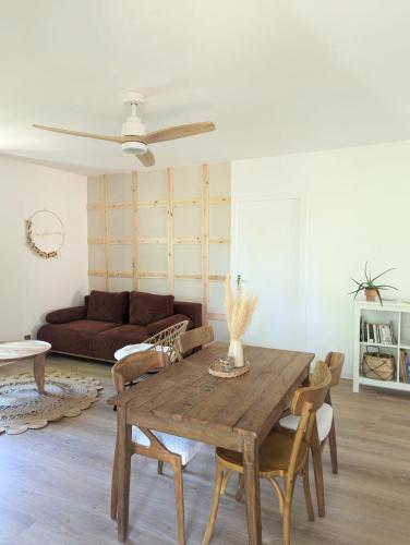 un salon avec une table en bois et un canapé dans l'établissement Gîtes Les Petits riens, à Balazuc