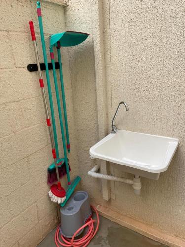 a bathroom with a sink and two mop at Apartamento Completo in Botucatu