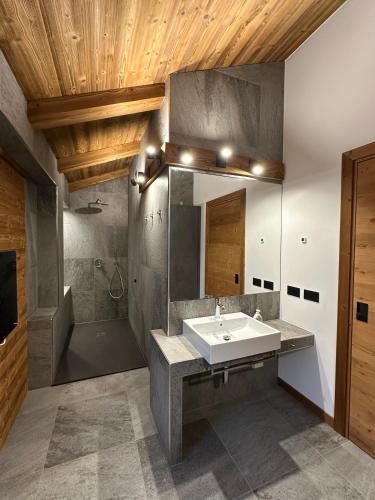 a bathroom with a sink and a shower and a mirror at Valtellina SkyLine EST in Villa di Tirano
