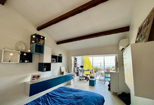 une chambre avec un lit bleu et un balcon dans l'établissement maison entièrement climatisée vue d'exception mer et rade de Marseille avec piscine 8 personnes, à Marseille