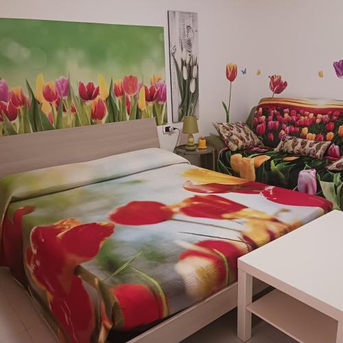 a bedroom with a bed and a painting of tulips at Affittacamere Il Conte in Follonica