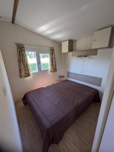 une chambre avec un grand lit dans une pièce dans l'établissement Mobil-home 8 pers CAMPING TIKAYAN LES CIGALES AU MUY, au Muy