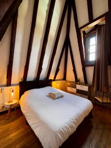 une chambre avec un grand lit dans un grenier dans l'établissement Les Galeries de Beaulac, à Pézenas