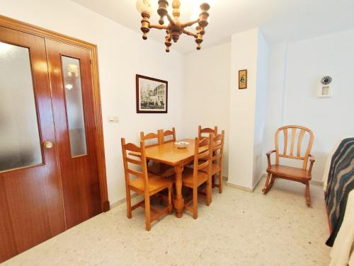 jadalnia z drewnianym stołem i krzesłami w obiekcie Top Rota Playa La Costilla Costa de la Luz w mieście Rota