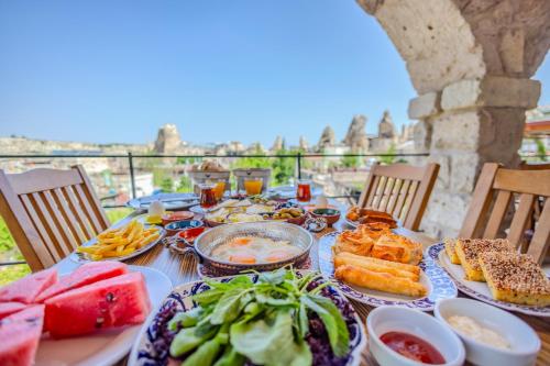 a table topped with plates of food on a balcony at Onur Cave Cappadocia in Goreme