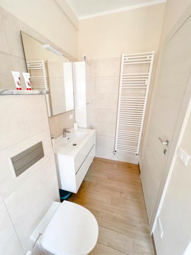 a bathroom with a white toilet and a sink at Don Pedro Beach House in Savona
