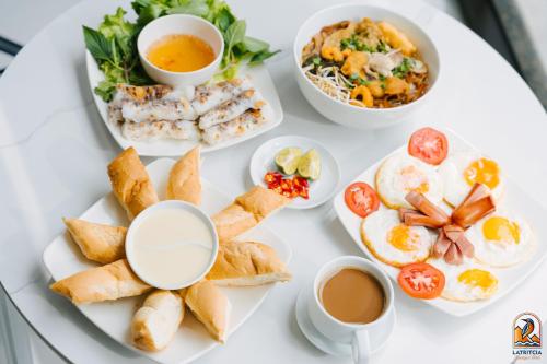een witte tafel met borden ontbijtproducten bij Latritcia Boutique Hotel in Cat Ba
