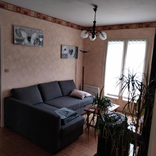 a living room with a couch and a table at La Maison Trèfle in Vieux-Rouen-sur-Bresle