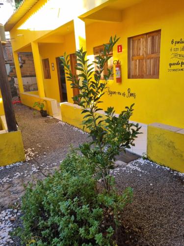 a yellow building with a plant in front of it at Vila do Chaves in Itaúnas
