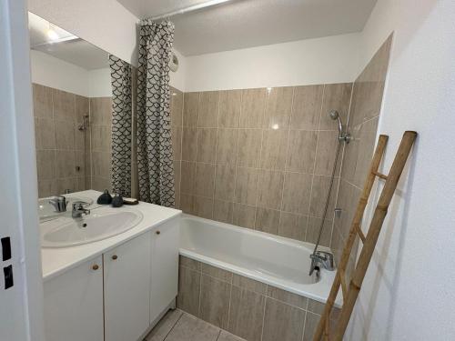 une salle de bain avec un lavabo et une baignoire dans l'établissement Appart calme sur Metz Terrasse, Piscine, Parking, à La Celle-sous-Gouzon