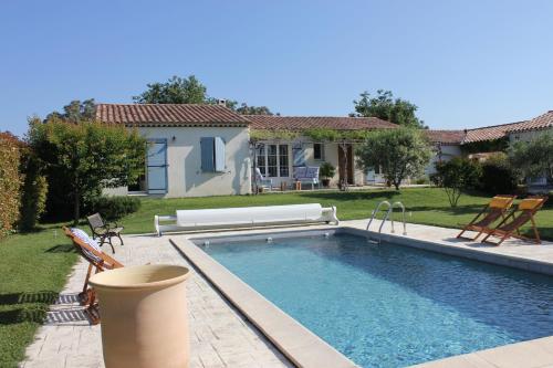 une piscine avec deux chaises et une maison dans l'établissement La Riclauchette, à Maillane