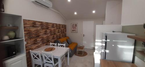 une petite cuisine avec une table et un réfrigérateur dans l'établissement Les chants du bonheur, à Saint-Génis