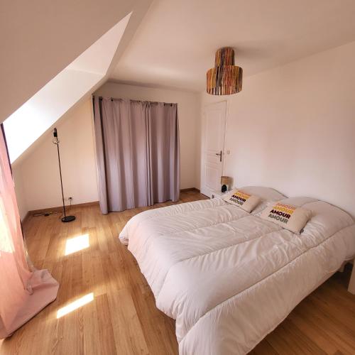 une chambre avec un grand lit blanc dans une pièce dans l'établissement La Maison de Joséphine, à Pleuven