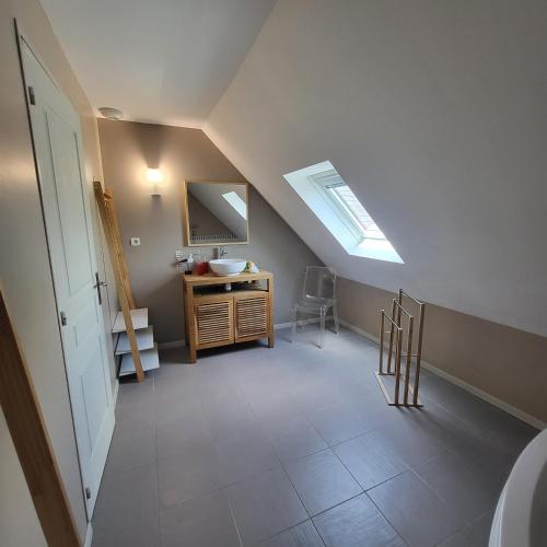 une chambre mansardée avec un lavabo et une lucarne dans l'établissement La Maison de Joséphine, à Pleuven