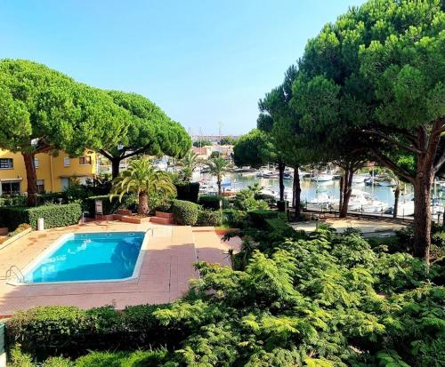 une piscine devant une maison avec des arbres dans l'établissement Le Roof-top du Cap, au Cap d'Agde