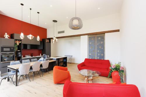 Il comprend un salon doté d'un mobilier rouge et une cuisine. dans l'établissement RARE-Superbe appt Suquet, jardin,6p,200m Croisette, à Cannes