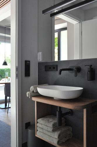 a bathroom with a white sink and a mirror at DIE NEUN - Loft, Garten, Lieblingsort in Bad Wörishofen