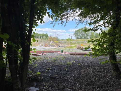 une vue d'un chantier de construction à travers les arbres dans l'établissement Chambres et tables d hôtes du Boiziller, 
