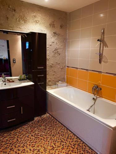 une salle de bain avec une baignoire et un lavabo dans l'établissement Les Galeries de Beaulac, à Pézenas