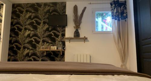 - une chambre avec un lit et du papier peint noir et blanc dans l'établissement Chambres et tables d hôtes du Boiziller, 