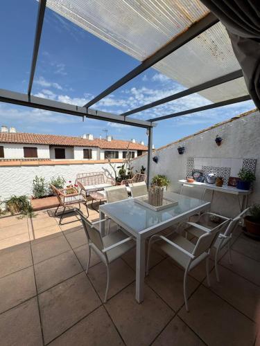 un patio avec une table et des chaises sur un patio dans l'établissement Appartement climatisé toit terrasse à la mer, à Saintes-Maries-de-la-Mer