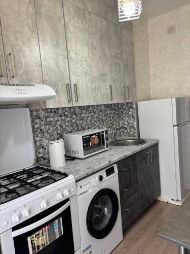 een keuken met een wasmachine en een magnetron bij Comfortable appartment in Salor Bekati