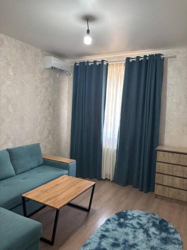 een woonkamer met een blauwe bank en een tafel bij Comfortable appartment in Salor Bekati