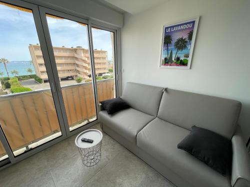 - un salon avec un canapé et de grandes fenêtres dans l'établissement Studio Horizon - Le Lavandou, au Lavandou