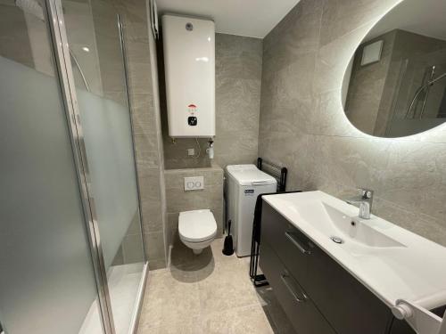 une salle de bain avec toilettes, lavabo et miroir dans l'établissement Studio Horizon - Le Lavandou, au Lavandou