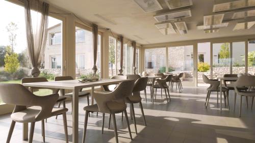 a restaurant with tables and chairs and windows at Borgo del Lago in San Gemini