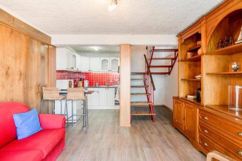 a living room with a red couch and a kitchen at Villa Sea Shore by Villa Plus in Gaula