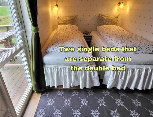 two single beds that are separate from the double bed at Country House surrounded by beautiful nature in Habo