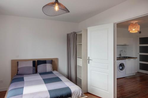 - une chambre avec un lit et un lave-linge dans l'établissement Les suites de Jeanne, à Orléans