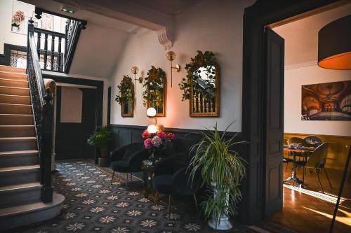 - un hall avec des chaises et une table fleurie dans l'établissement HOTEL DES DAUPHINS, à Bourgoin-Jallieu