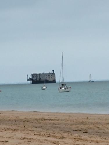 two boats sitting in the water near a beach at Mobilhome neuf 3 chambres Oléron in Saint-Denis-dʼOléron