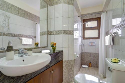 a bathroom with a sink and a toilet at Villa Heracles by Villa Plus in Peyia