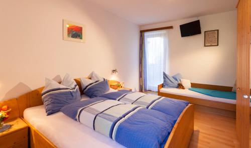 une chambre avec un lit avec des oreillers bleus et blancs dans l'établissement TAMERBURGERHOF, à Lienz