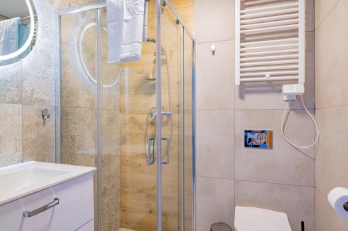 a bathroom with a shower and a toilet and a sink at Baltic Sport in Władysławowo