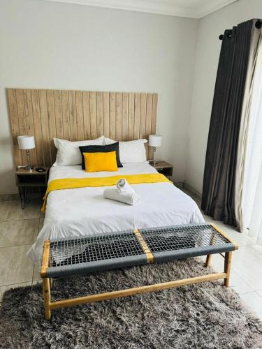 a bedroom with a large bed with a wooden headboard at Kioma Guest House in Mokopane