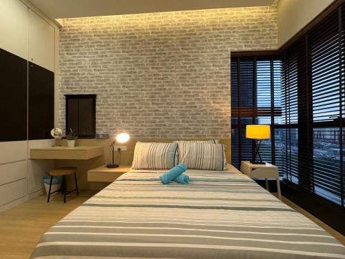 a bedroom with a large bed and a brick wall at Designer Touch Luxurious Stay with Infinity Pool in Petaling Jaya