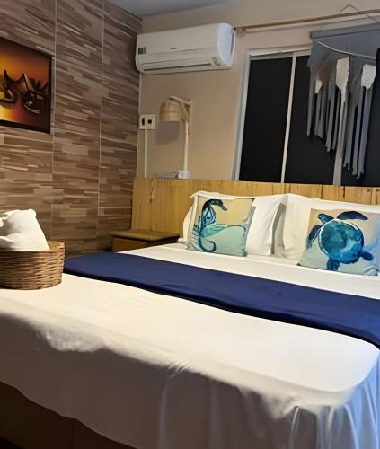 a bedroom with a large bed with blue and white pillows at Sua Casa em Noronha - Conforto e Charme na Pousada da Iris in Fernando de Noronha