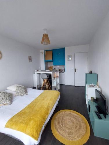 une chambre avec un grand lit et une télévision dans l'établissement Le Patio, à Courseulles-sur-Mer