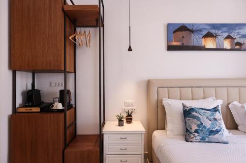 a bedroom with a bed and a dresser with a night stand at Galini Hotel in Mýkonos City