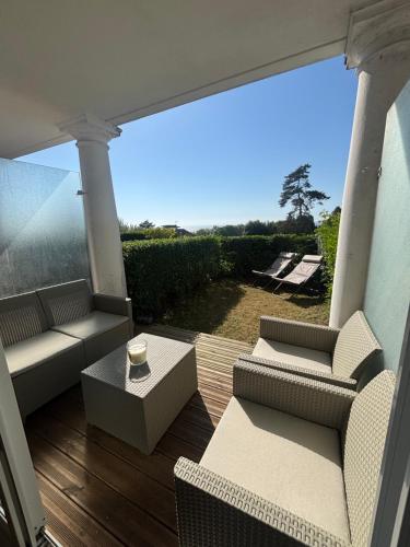 - une terrasse couverte avec des chaises et une vue sur l'océan dans l'établissement Studio Jardin avec Terrasse VUE MER, à Trouville-sur-Mer