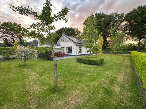 a small white house with a yard with a yard at Vakantieverblijf De Hoge Boekel in Enschede